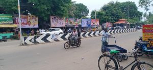பேருந்து நிறுத்தத்தில் நிழற்குடை இன்றி தவிக்கும் பள்ளி மாணவ மாணவிகள் மற்றும் பயணிகள்.